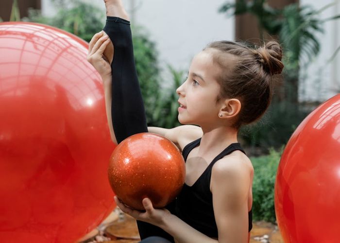 Athletic person doing rhythmic movement exercises in a dark room.